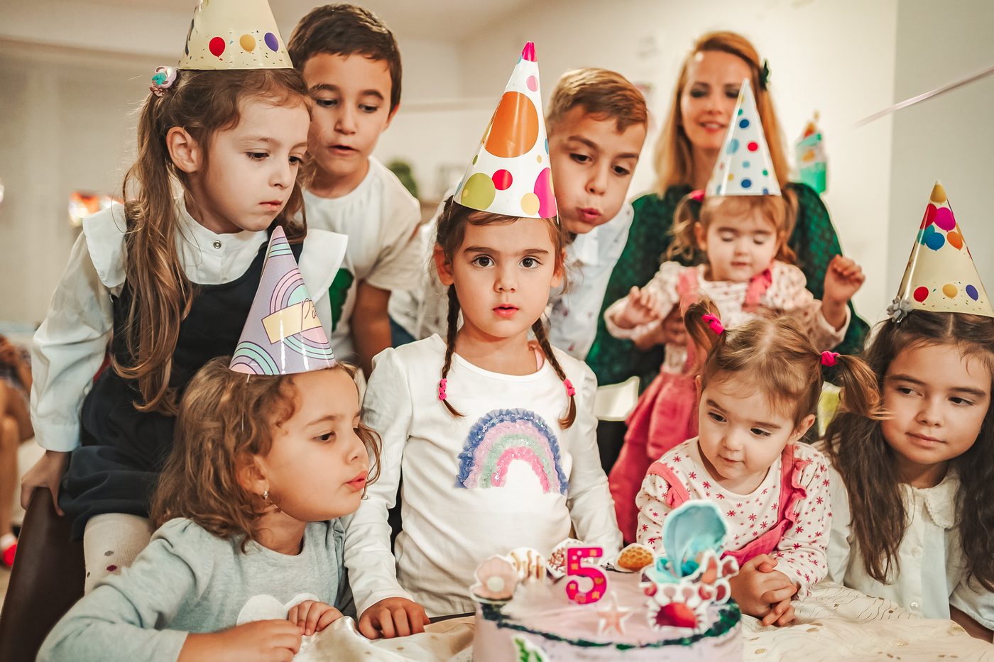 Children gathered around a birthday cake