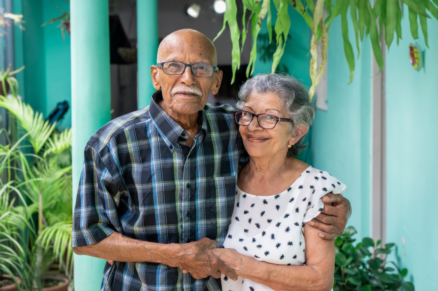 An older couple standing together on a porch