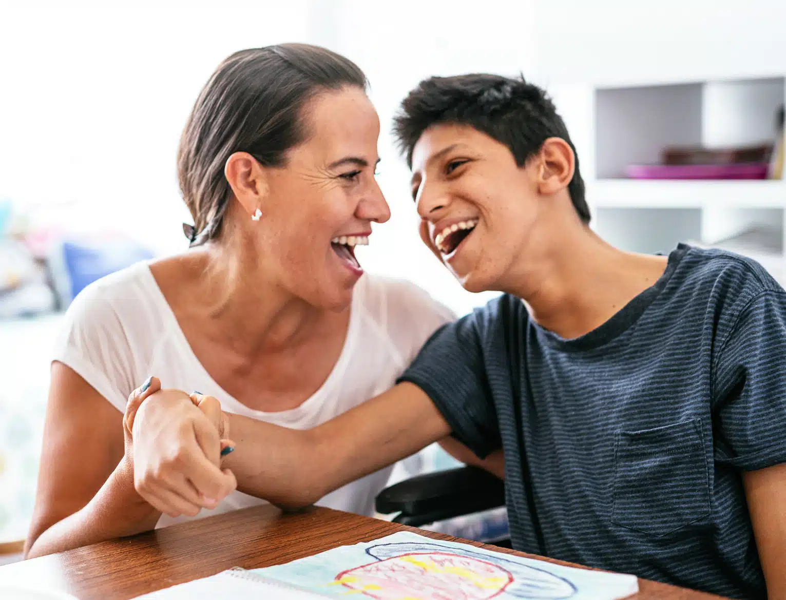 Graphic of a mother and her son with special needs. They are happy and she is holding his wrist.